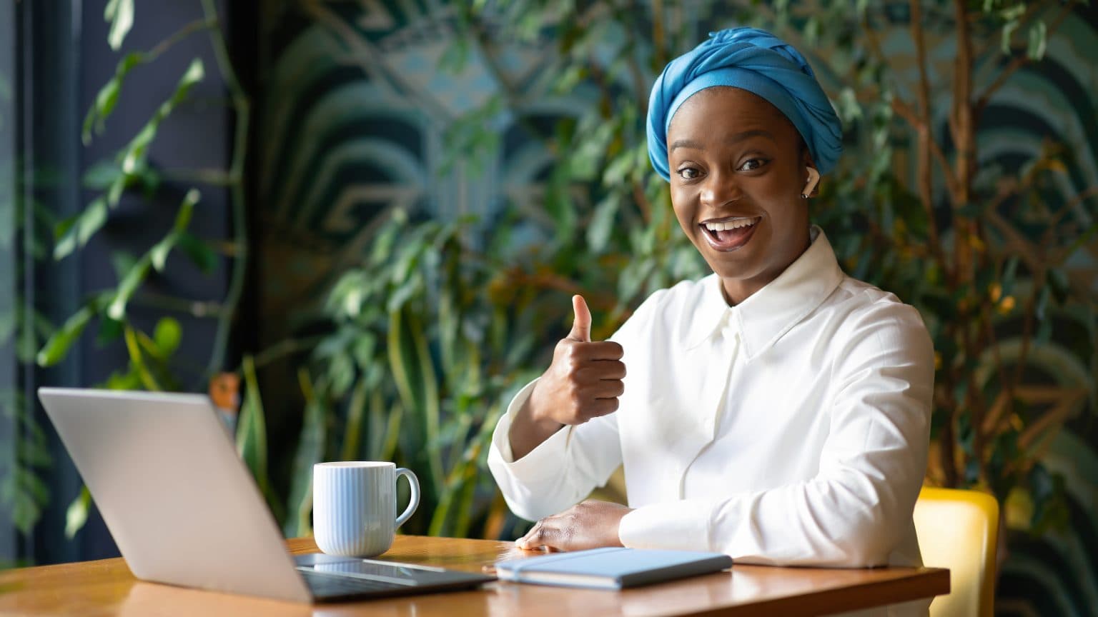A cheerful African professional working on a laptop